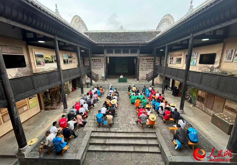 参加研学的学员在红一军团司令部旧址聆听长征故事。人民网记者 刘祎摄